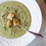a bowl of soup with croutons on top.