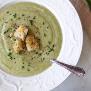 a bowl of soup with croutons on top.