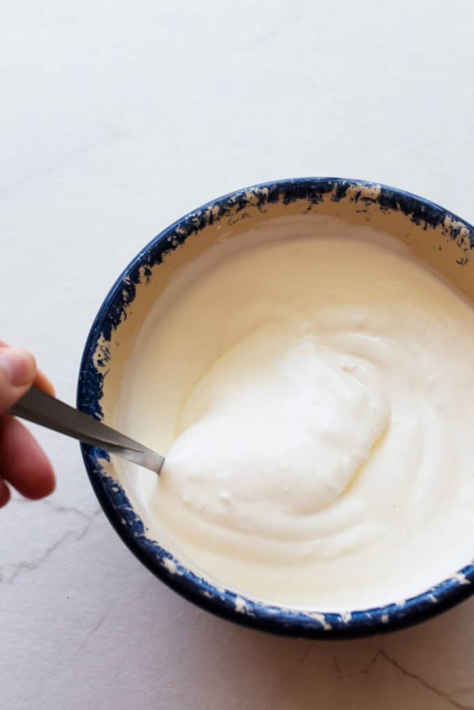 Stirring salt into yogurt for labneh.