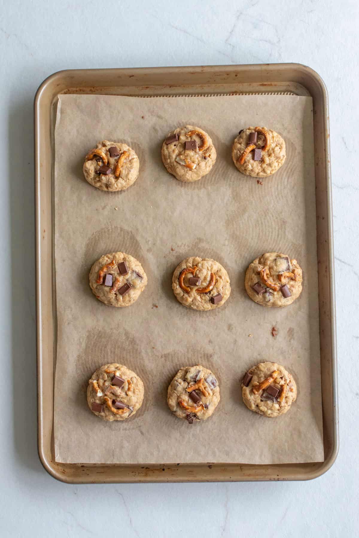 Cookie dough balls on a parchment lined baking sheet.