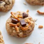 Lactation cookie with oatmeal, pretzels, and chocolate chunks on a countertop.