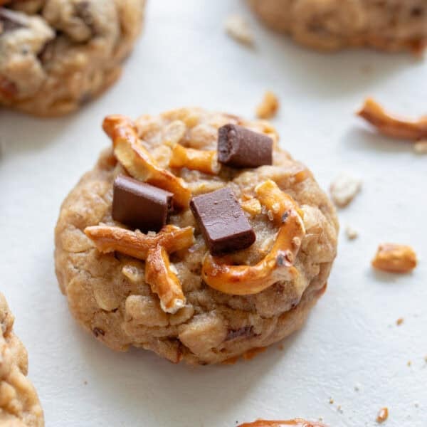 Lactation cookie with oatmeal, pretzels, and chocolate chunks on a countertop.