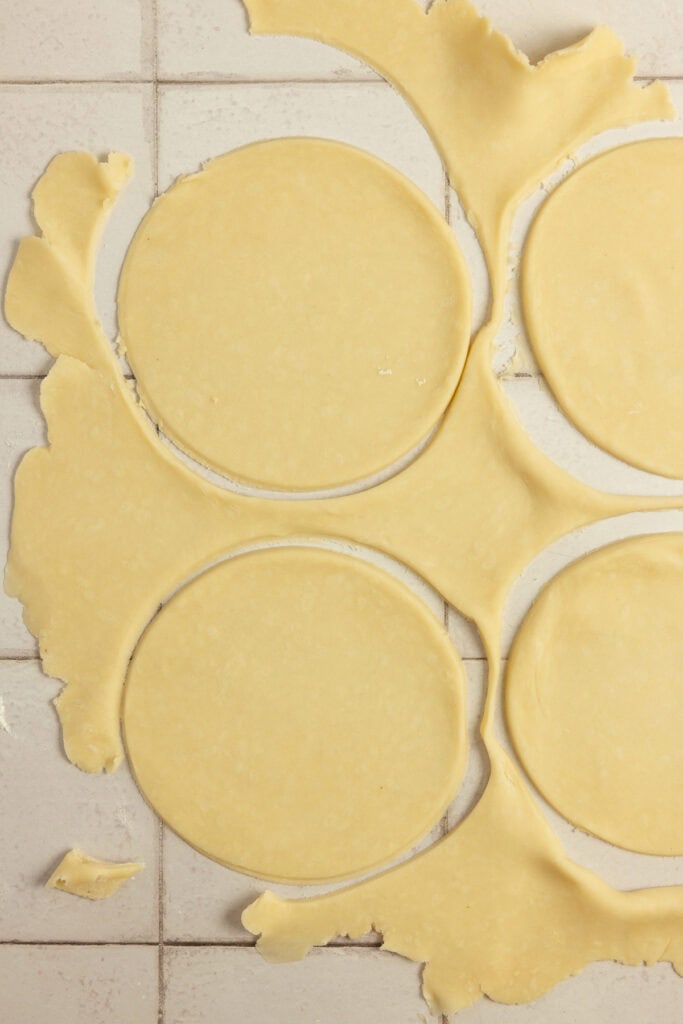 Cutting out pie dough into circles.