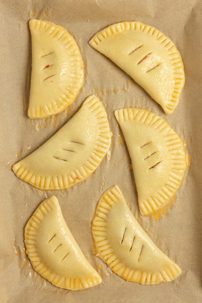 6 hand pies on parchment paper.