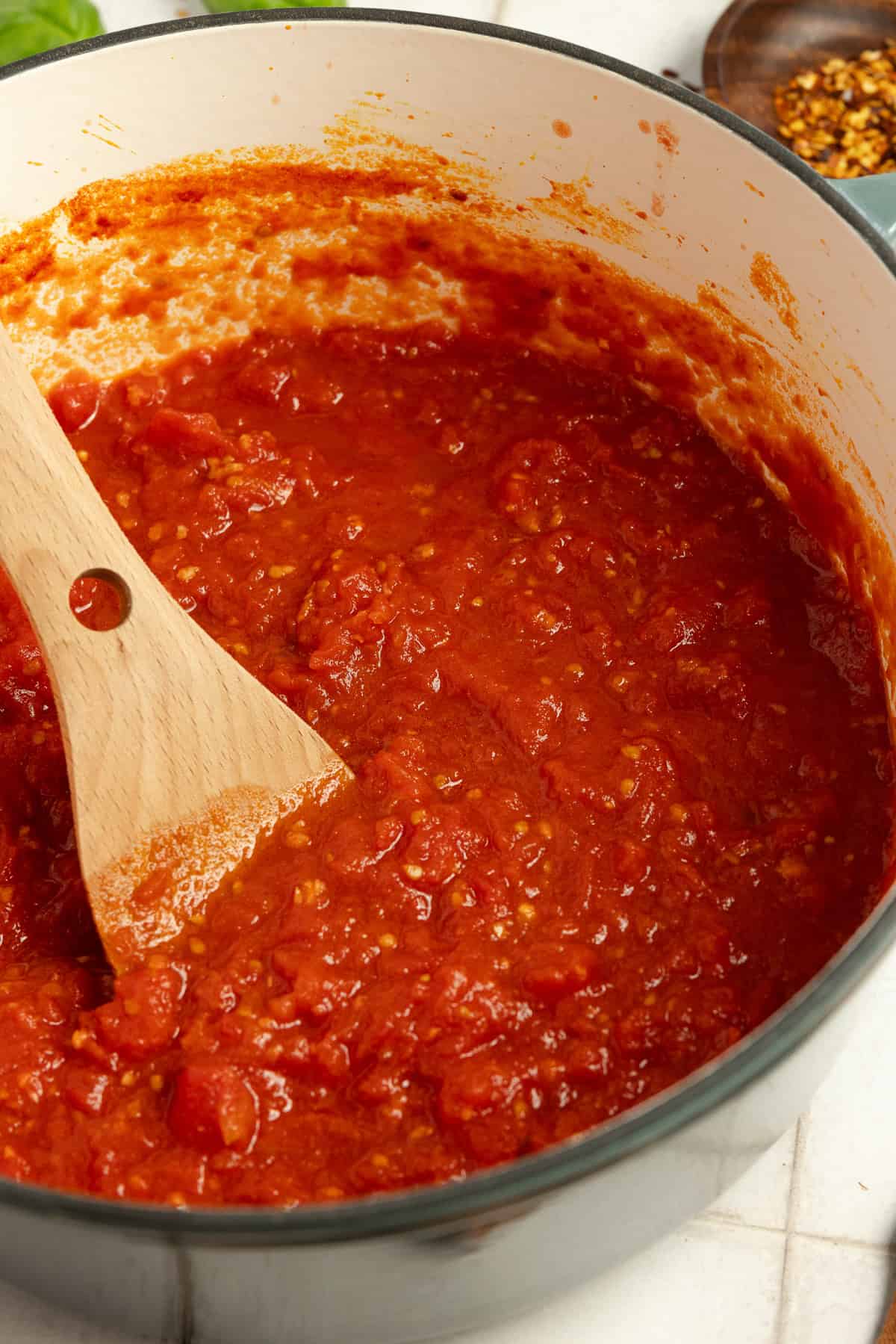 Marinara sauce cooking in a Dutch oven.