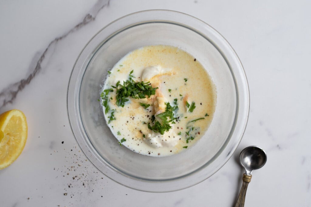 Mayo, milk, sour cream, and spices in a bowl.