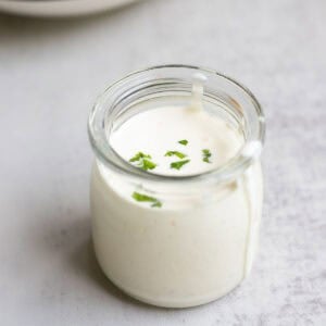 ranch dressing in a glass jar on a countertop.