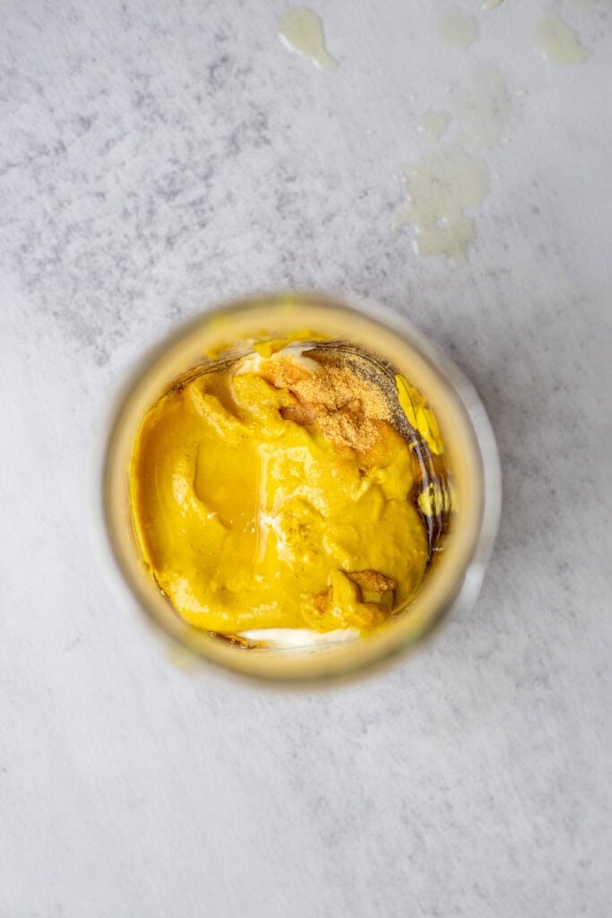 Mustard, honey, mayo, lemon juice and spices in a mason jar.