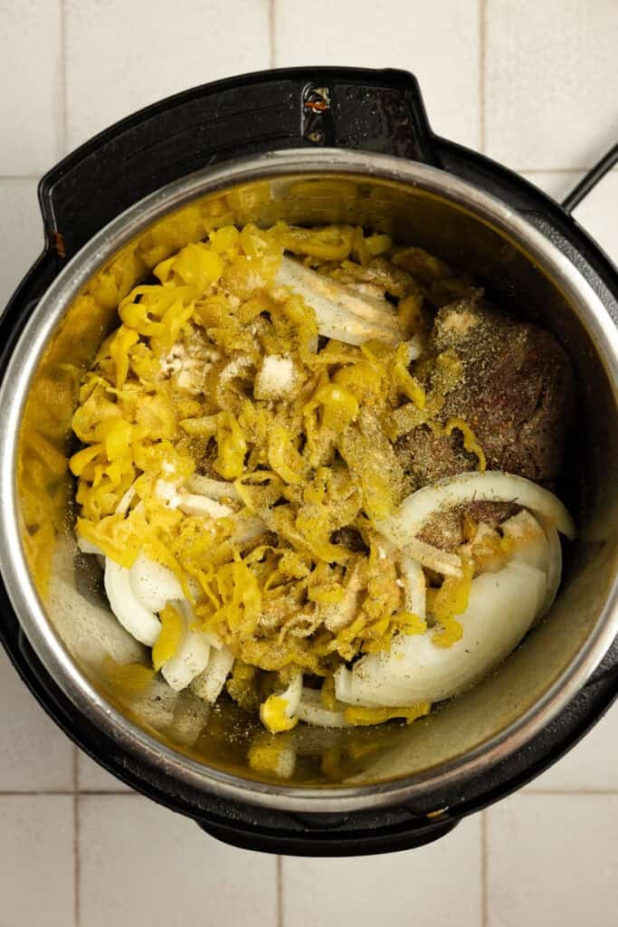 Beef and other ingredients added to an instant pot.
