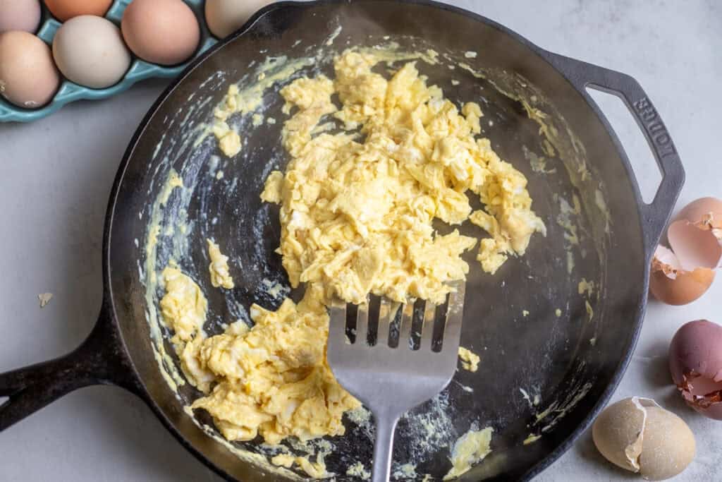 Mixing cooking scrambled eggs on a pan.