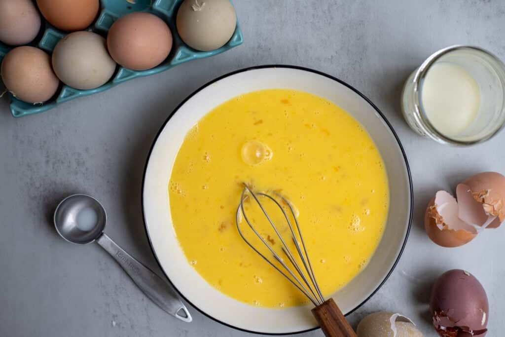 Eggs, and milk mixed into a bowl.
