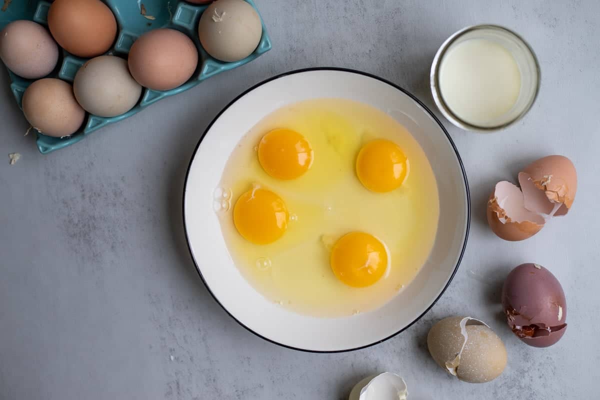 Egg yolks on a plate with egg shells on the side.