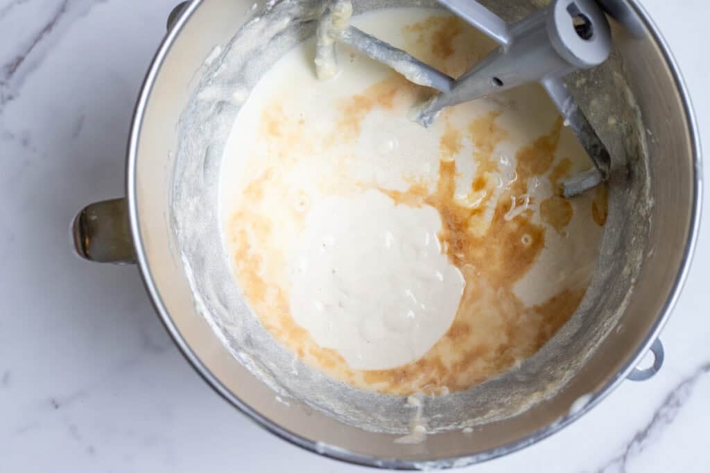 Wet ingredients added to a stand mixer bowl.