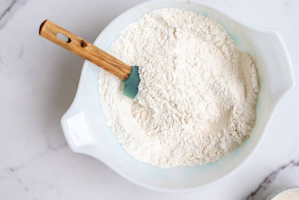 Flour, salt, baking soda, and baking powder mixed together in a bowl.