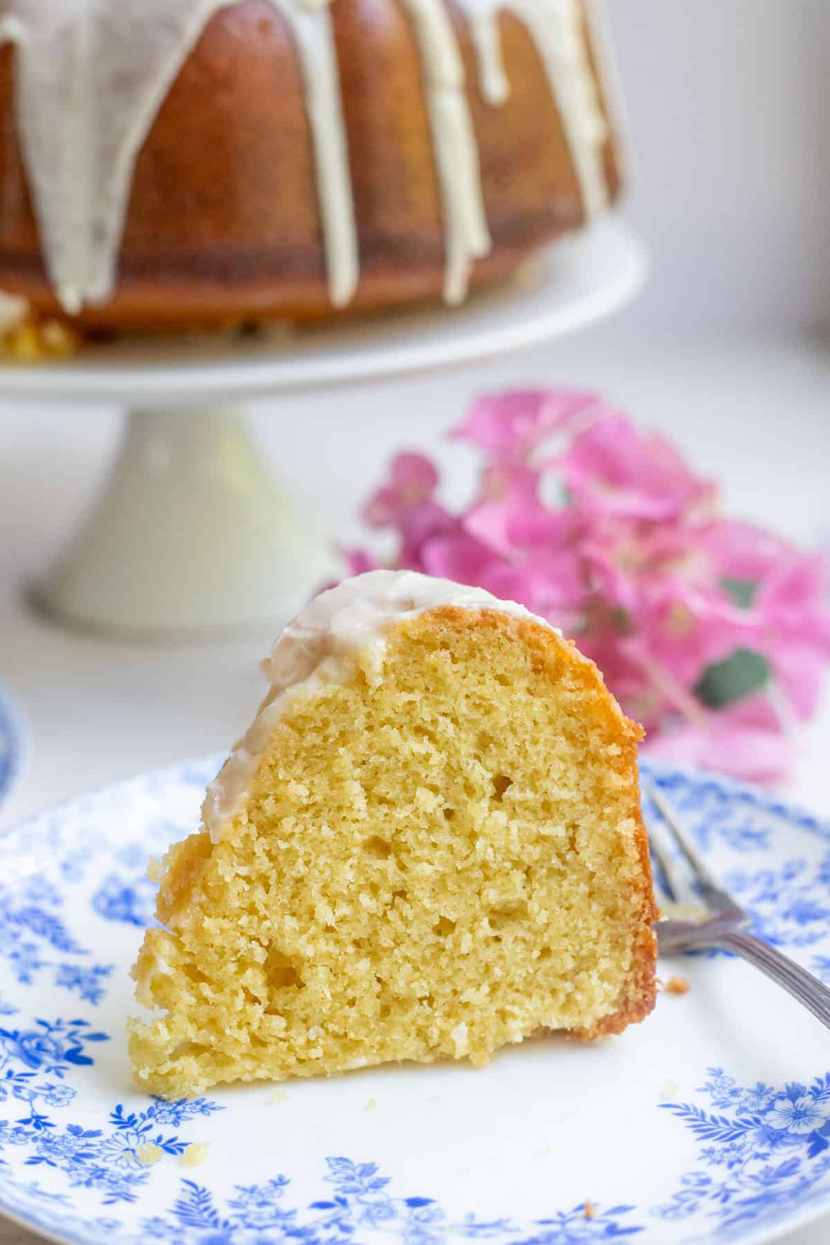 A slice of sourdough Bundt cake topped with icing on a plate.