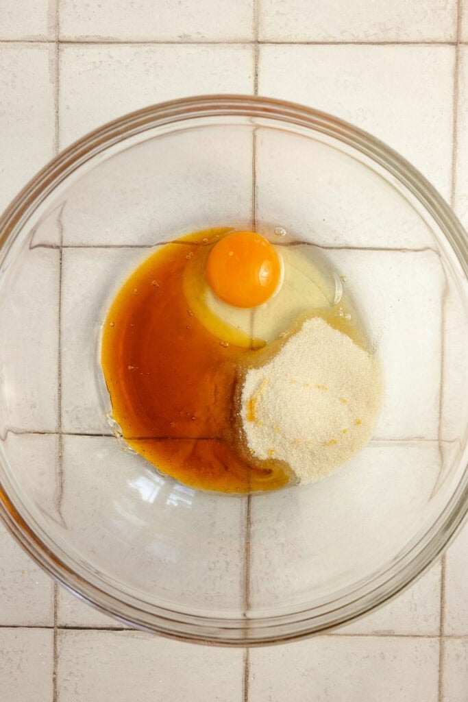 Egg and other ingredients in a glass bowl.