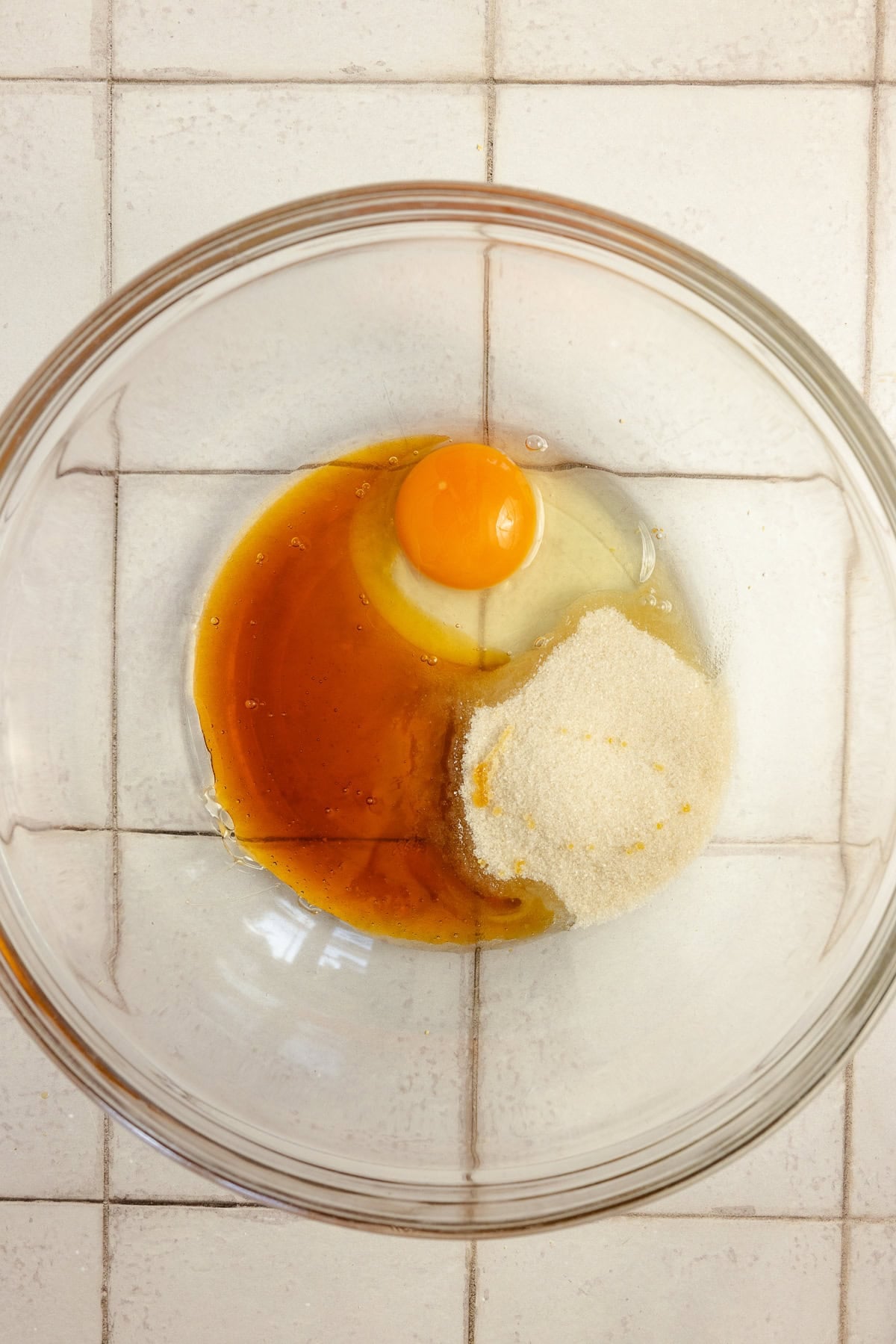 Egg and other ingredients in a glass bowl.