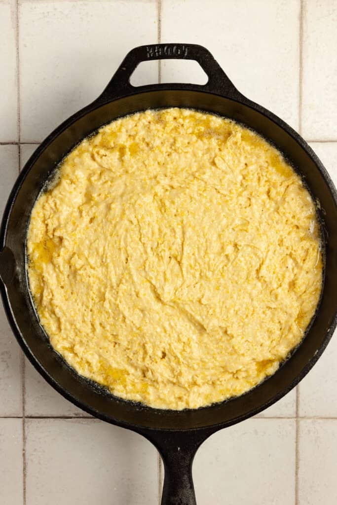 Cornbread batter in a cast iron skillet.