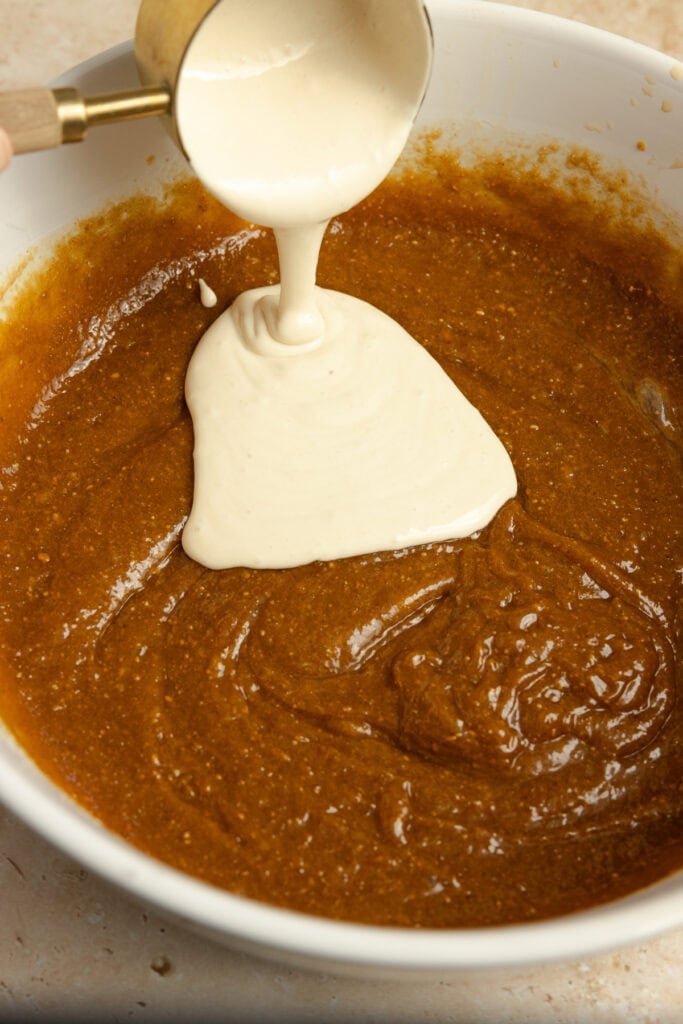 Sourdough discard poured into a bowl of wet ingredients.