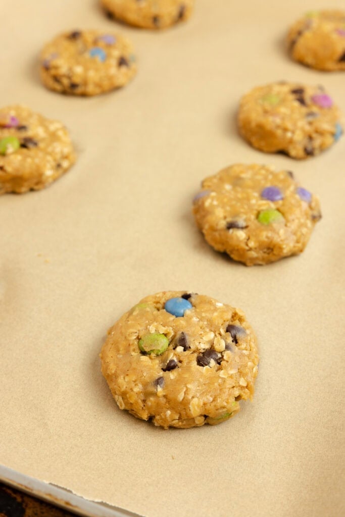 Cookie dough on a parchment lined baking sheet.