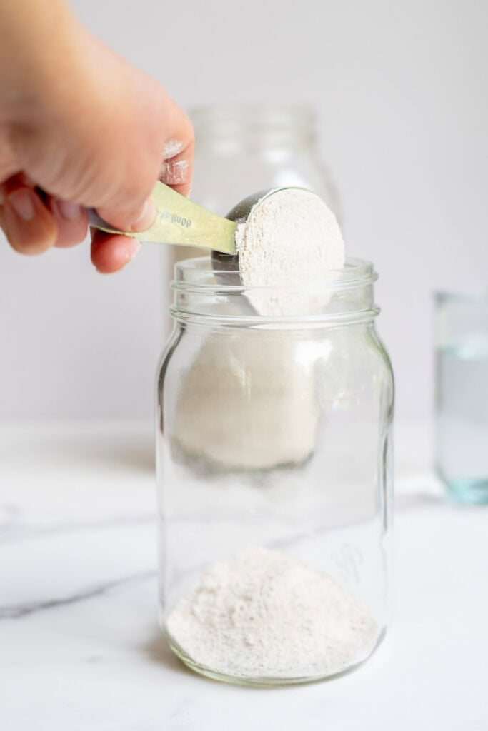 Adding flour to a jar.