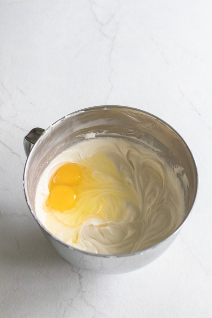 Egg yolks blended into a cream cheese mixture.