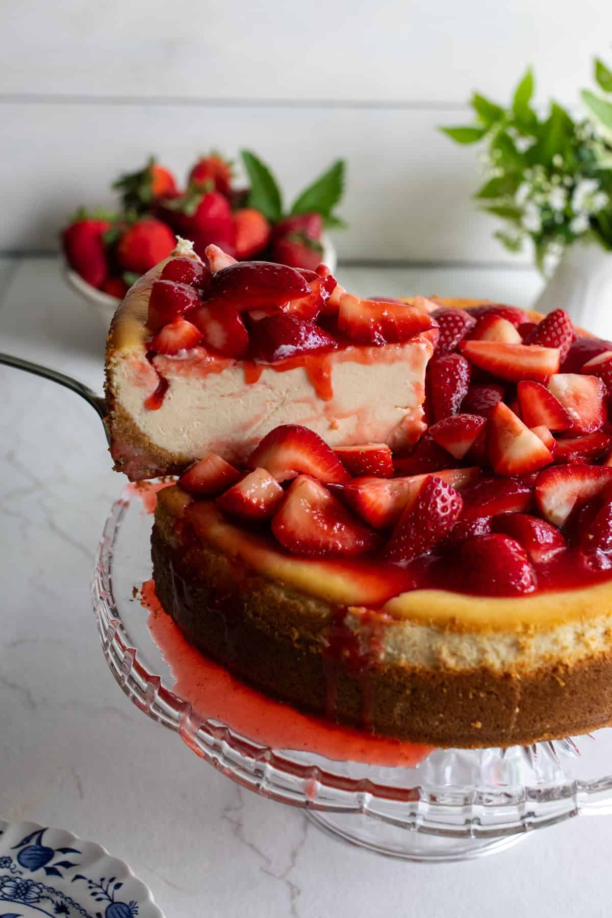A slice of cheesecake drizzled with strawberries.