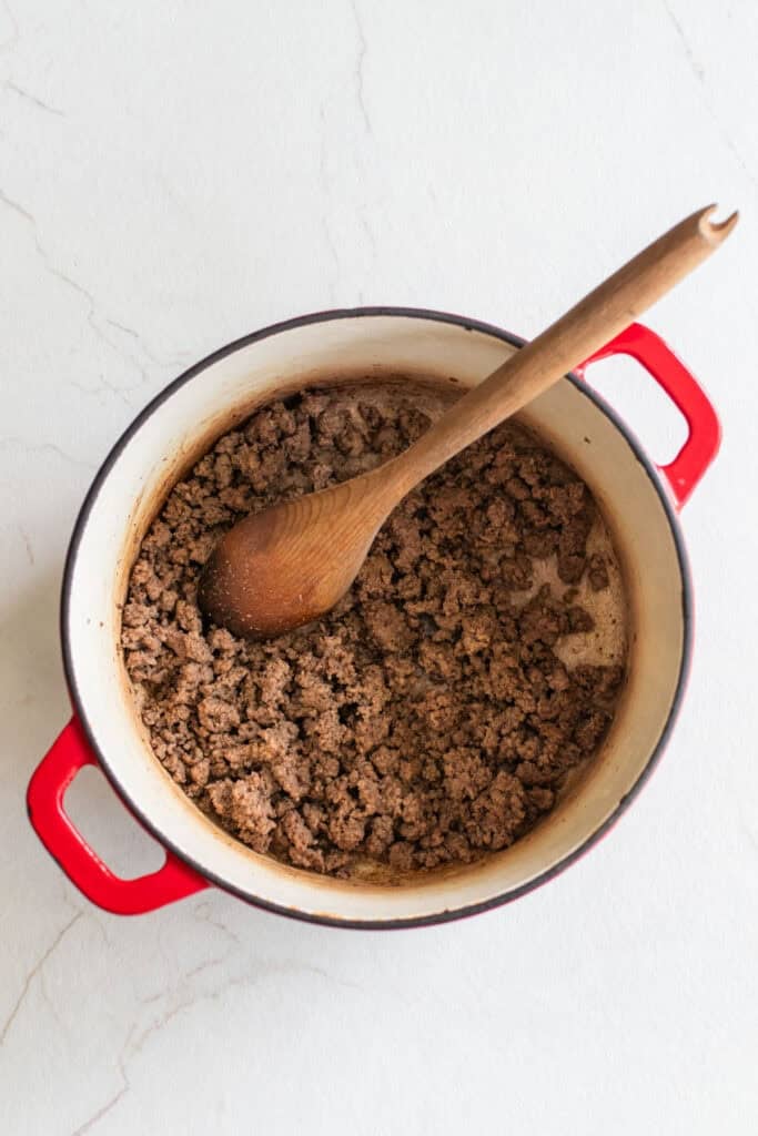 A Dutch oven sauteing ground beef.