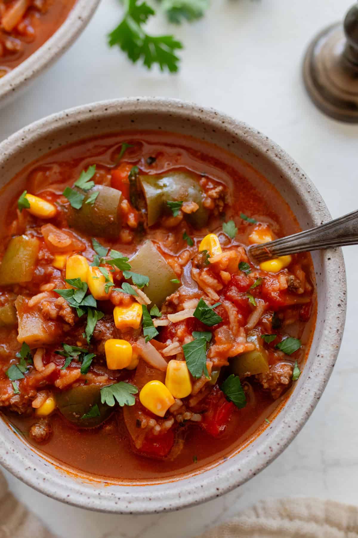 A bowl of stuffed bell pepper soup on a marble countertop.