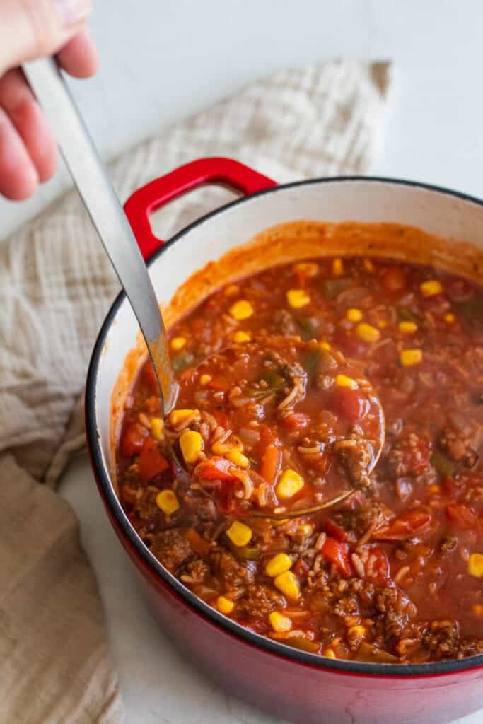 Stuffed bell pepper soup being served in a ladle.