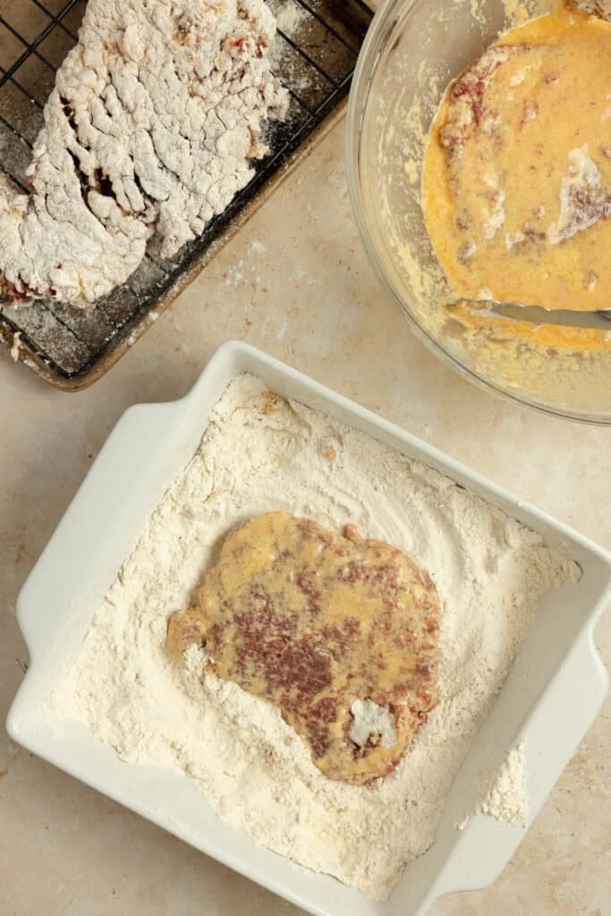 Dredging steaks in flour mixture.