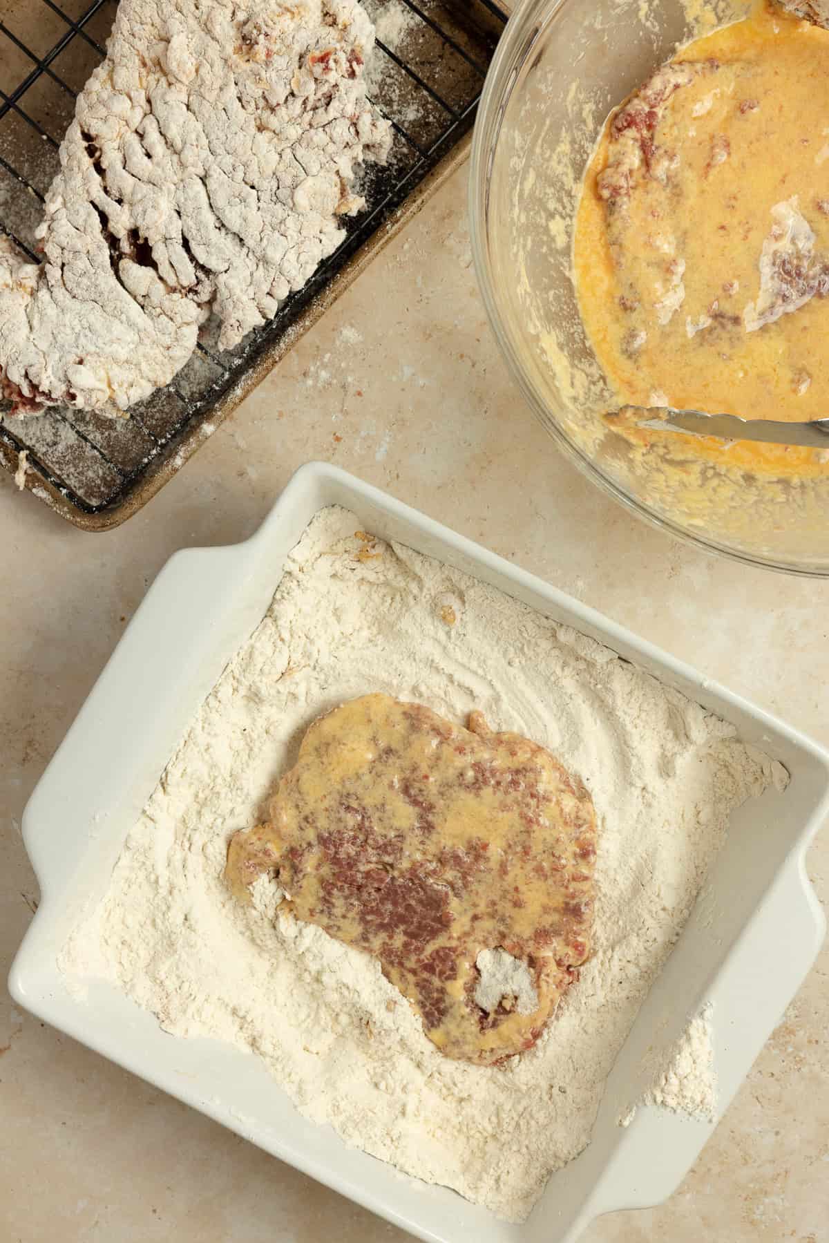 Dredging steaks in flour mixture.