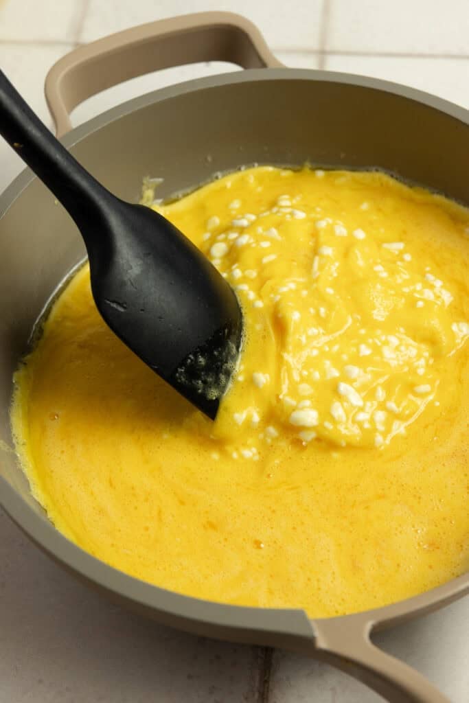 Stirring scrambled eggs in a skillet with a spatula as they set. 