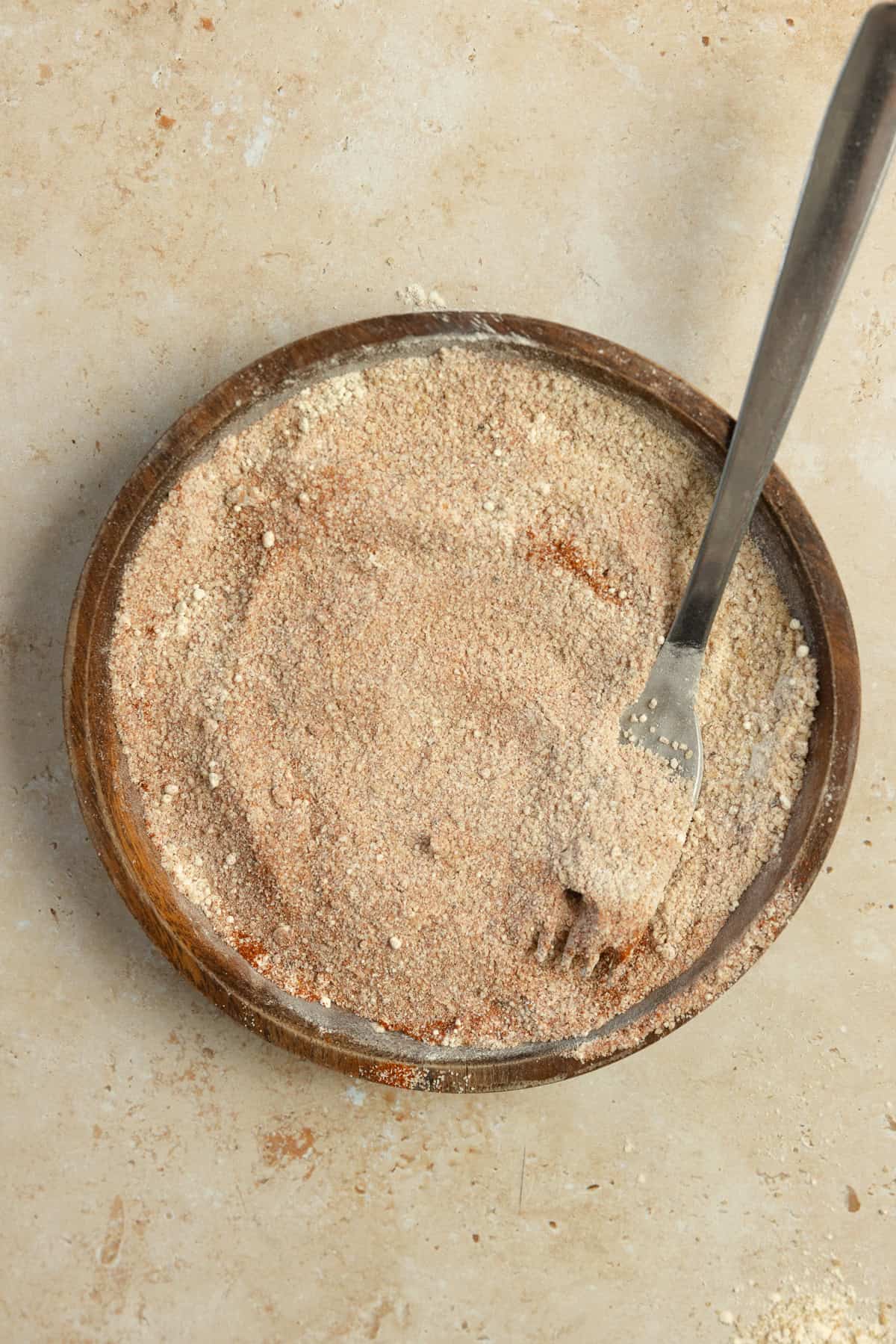 Mixing seasoning together in a bowl with a fork.