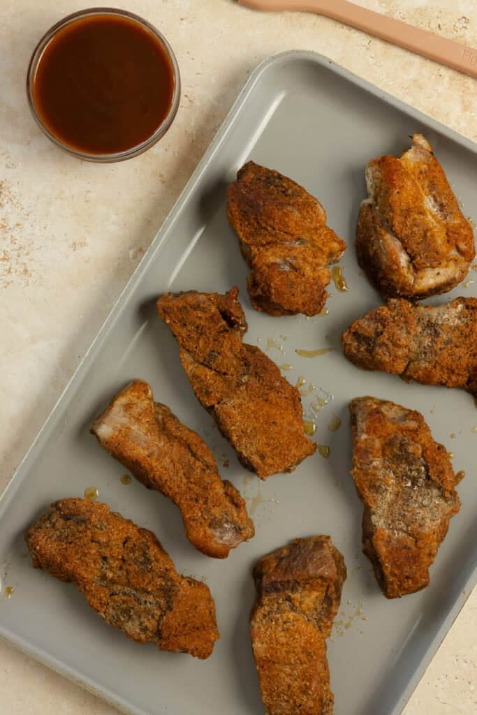 Sheet pan of baked ribs.