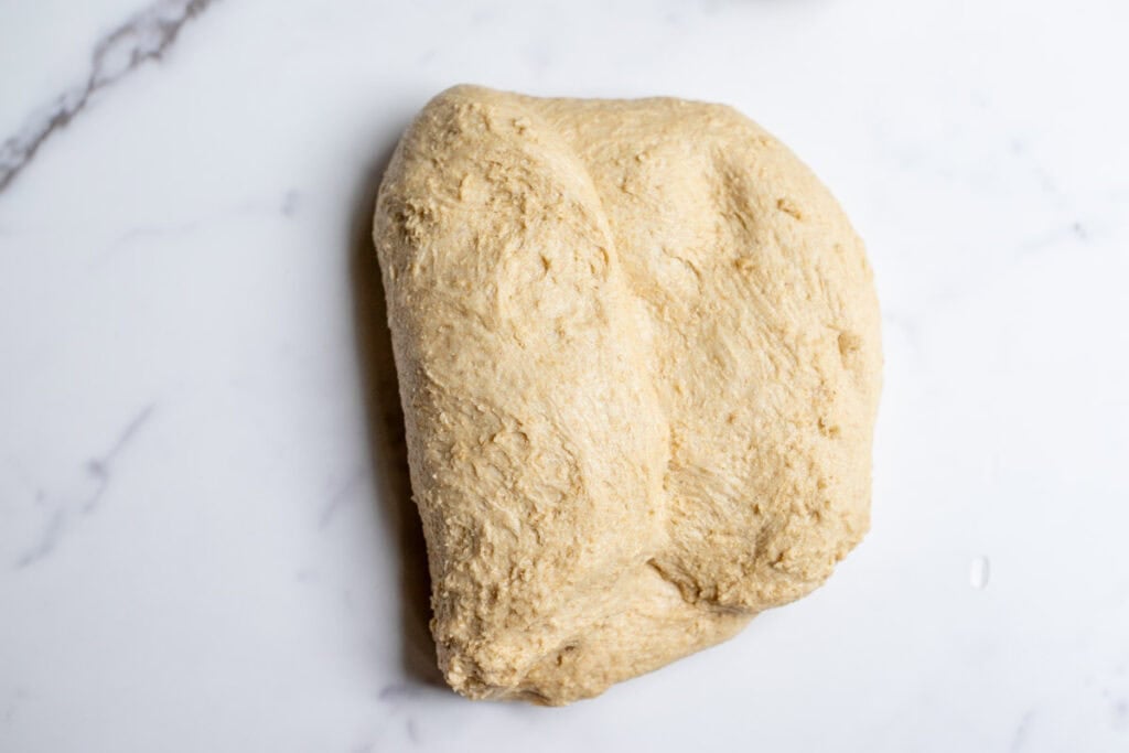 Shaping bread dough on a countertop.