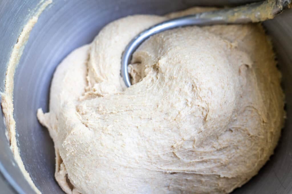 Fresh milled sourdough sandwich bread dough in a stand mixer with a dough hook.