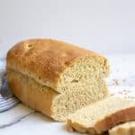 Sourdough sandwich bread with fresh milled wheat sliced up on a countertop.
