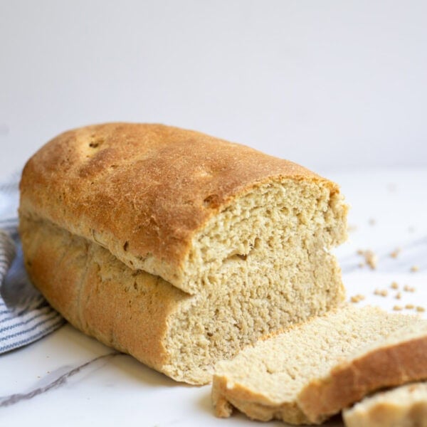 Sourdough sandwich bread with fresh milled wheat sliced up on a countertop.