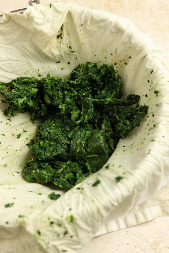 Washed spinach strained with a tea cloth.