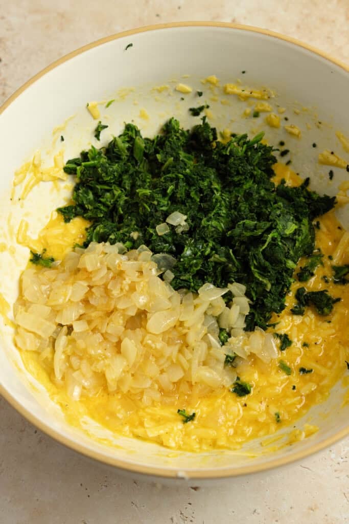 Eggs, cheese, spinach, and seasonings in a bowl.