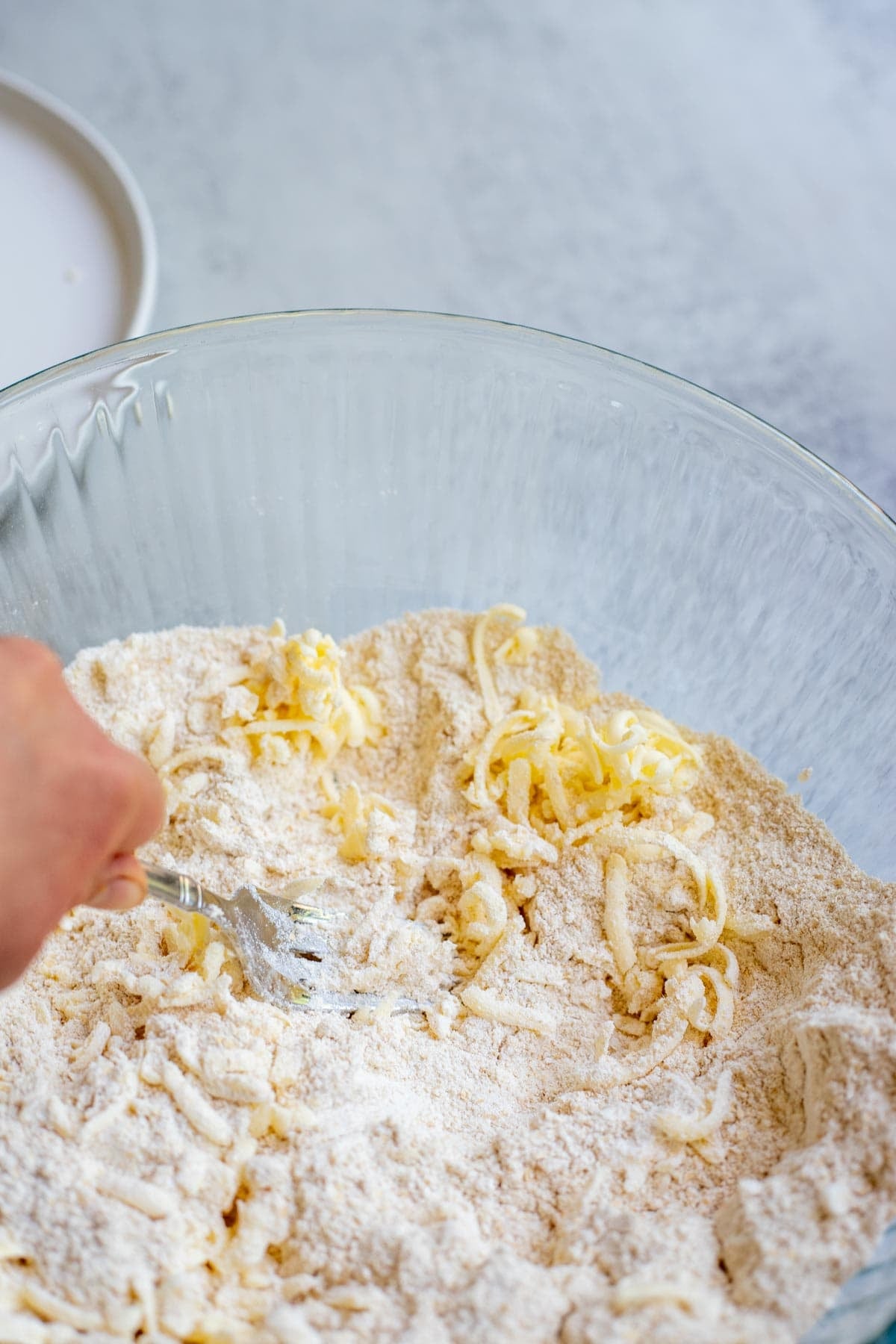 Grated butter and flour mixture being mixed together.