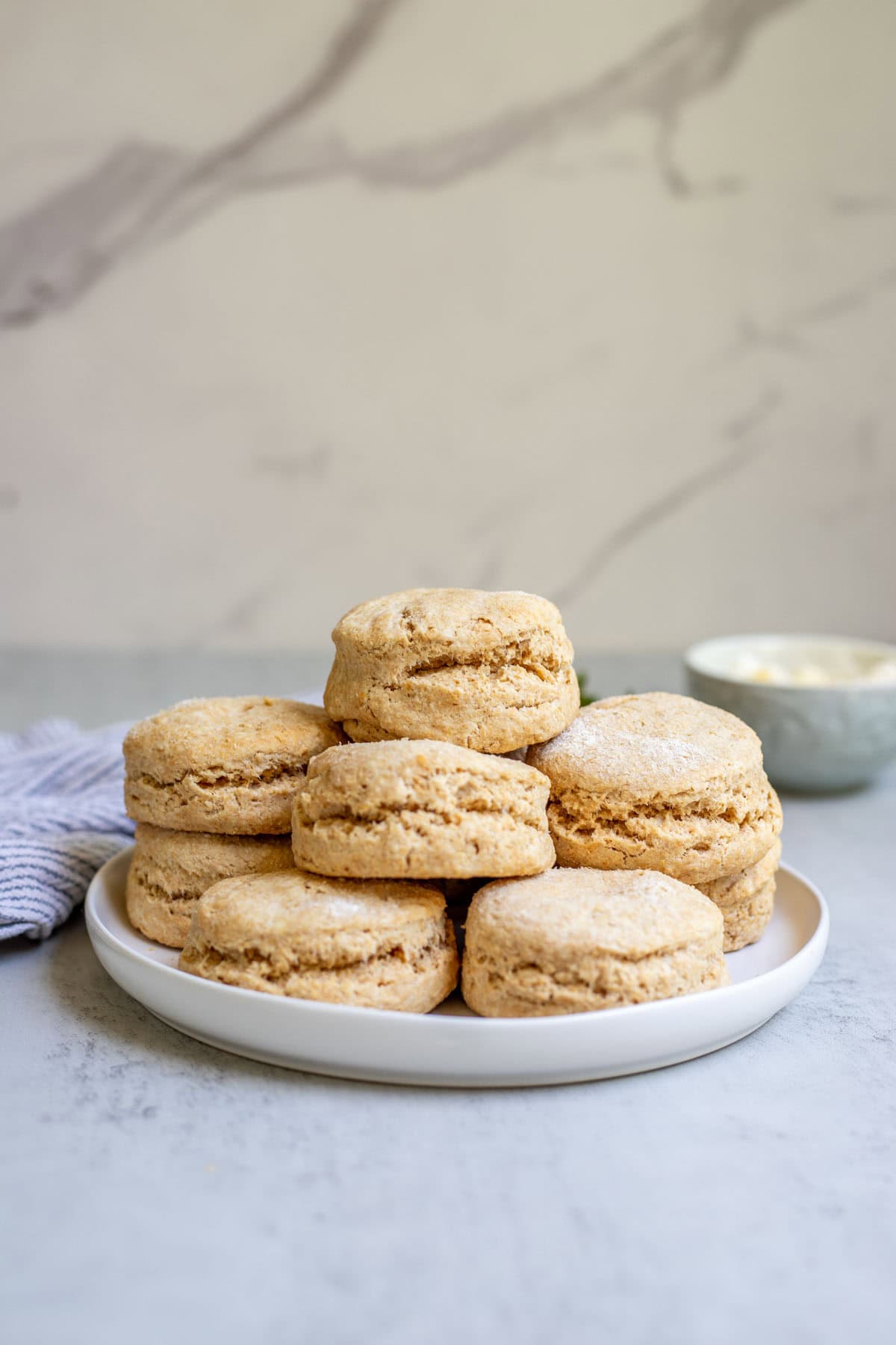 Whole wheat biscuits made with fresh milled flour stacked up on a plate.