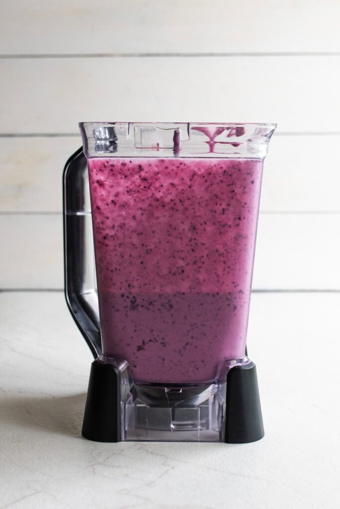 Blueberries blended in a blender with heavy cream and yogurt.