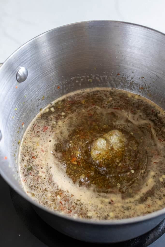Peppers, sugar, and vinegar cooking in a large pot.