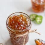 pepper jelly in a glass jar on the countertop.