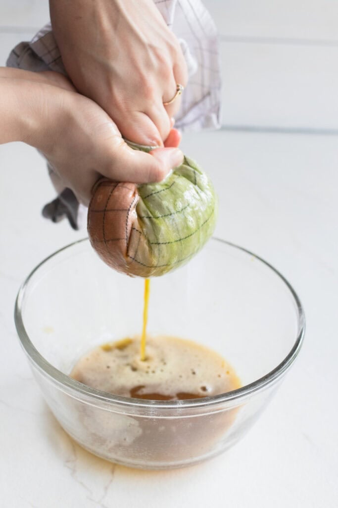 Squeezing out the excess juice from the bell peppers and jalapenos in a cheese cloth.