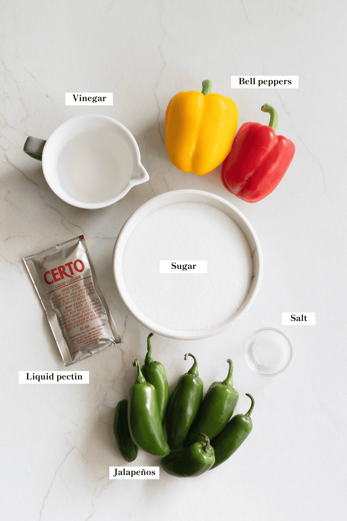 Bell peppers, jalapenos, sugar, salt, vinegar, and liquid pectin on the counter top.
