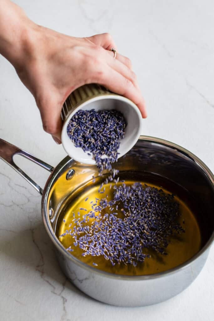 Lavender buds, water, and honey in a saucepan.