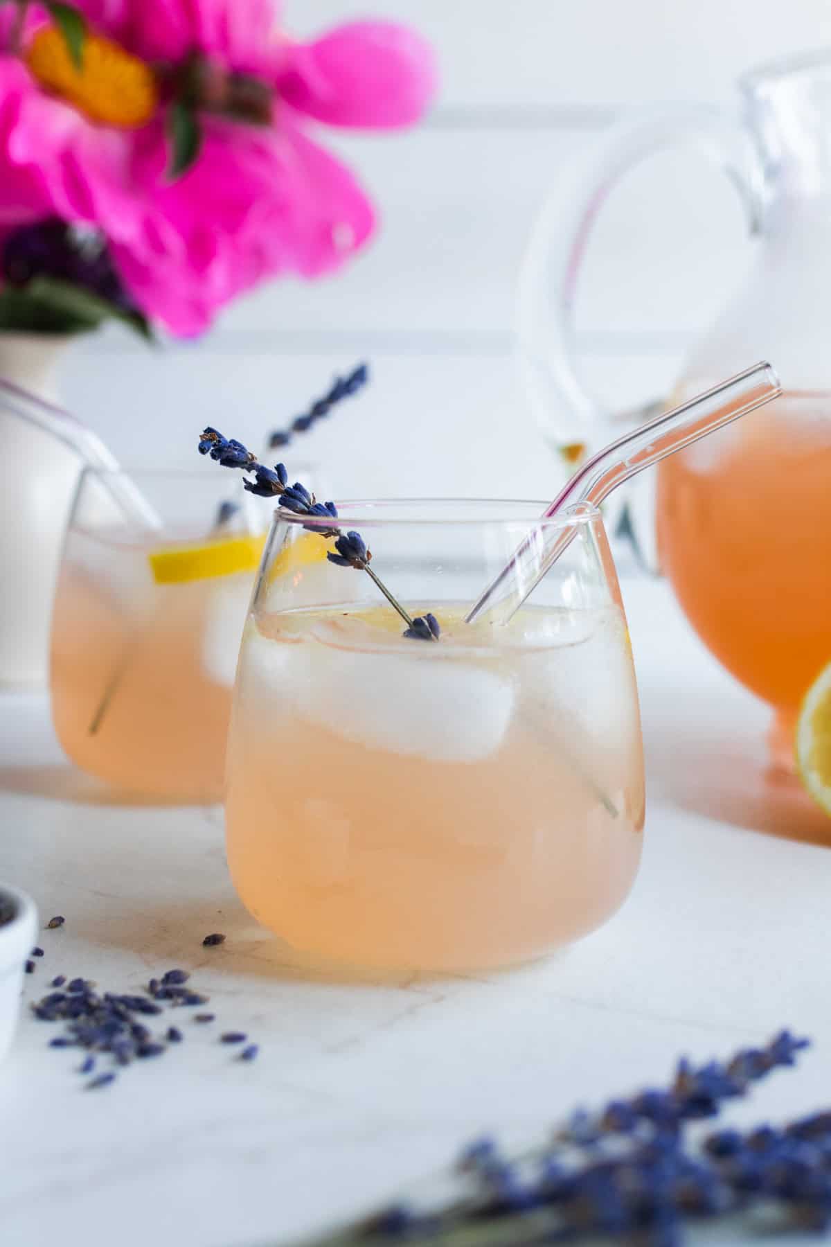 A glass of lavender lemonade sitting on the marble counter.
